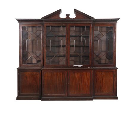 A GEORGE III MAHOGANY BREAKFRONT BOOKCASE, EARLY 19TH CENTURY with architectural pediment decorated with Greek key; above fou