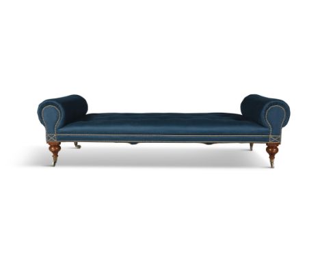 A VICTORIAN MAHOGANY FRAMED UPHOLSTERED DAYBED, with twin scrolled ends covered in a soft blue fabric with brass studding on 