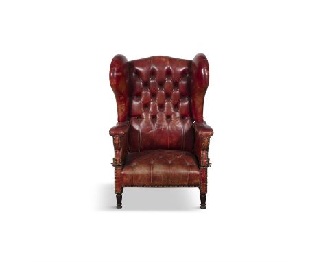 A BUTTON-BACK CLOSE-NAILED WINGBACK ARMCHAIR / WHEELCHAIR, 19TH CENTURY, upholstered in red/orange hide with adjustable arms 