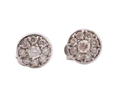 A pair of platinum and diamond stud earrings. The platinum stud earrings set with a central round brilliant cut diamond surro