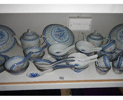 A shelf of modern oriental table ware including rice bowl, teapots, ladles etc.,