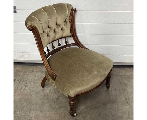 A button-back slipper chair, on turned and sabre supports, on castors