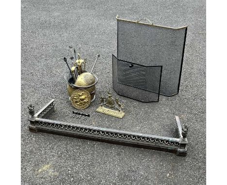 A brass coal scuttle, fire companion set, a brass fire kerb with reticulated scroll frieze and a cast brass andiron in the fo