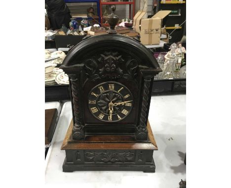 A Black forest cuckoo clock, arched form, with urn finial, Roman numeral clockface flanked by barley twist pillars on carved 