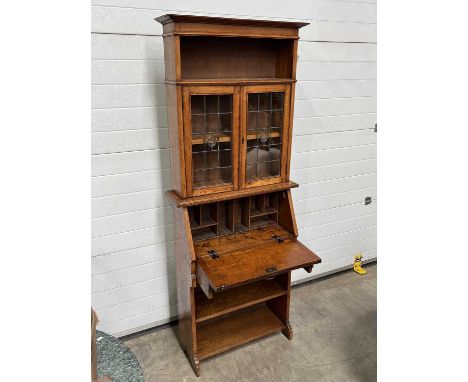 A bureau bookcase, single shelf and glass-front cabinet doors above fall-down slant front revealing pigeon holes, fitted sing