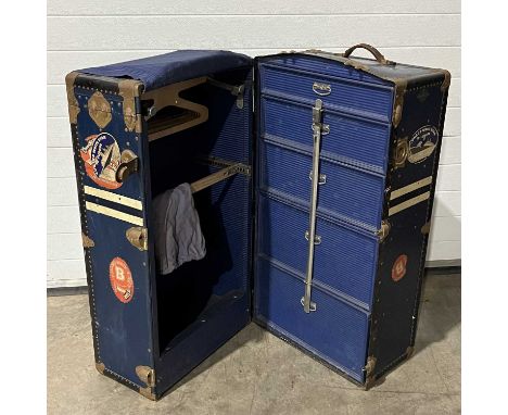 A vintage steamer trunk, decorated with "W.B.D" and various Cunard White Star stickers, fitted hanger section to one side, wi