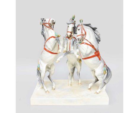 A Royal Worcester Porcelain Group "Circus Horses", by Doris Lindner, three rearing white circus horses in red bridlery, on a 