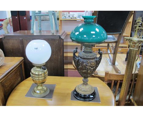 A XIX Century Cast Metal Shaped Oil Lamp, decorated with cherubs, on a circular base; together with a brass oil lamp, convert