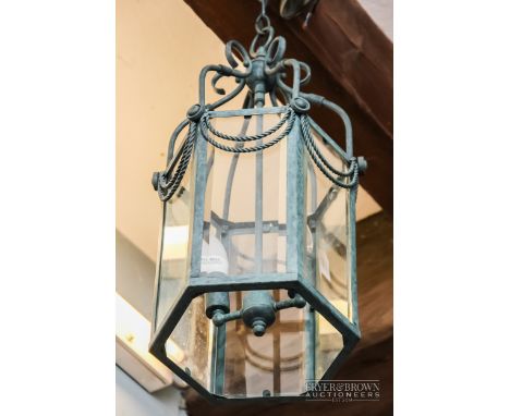 A contemporary light fitting in the form of a hexagonal hanging lantern with ornate swag decoration 
