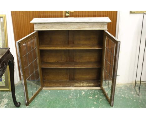 An oak display cabinet - limed and distressed - two leaded light glazed doors opening on to two adjustable shelves