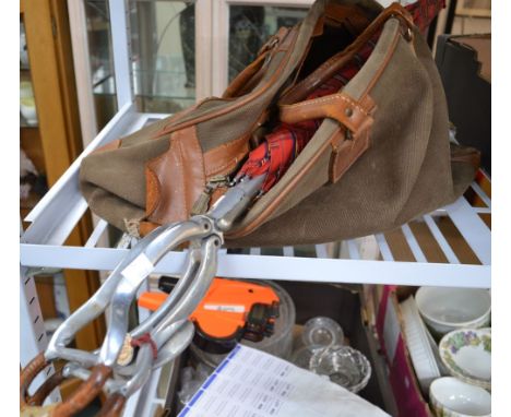 A canvas holdall containing cartridge belts with a umbrella seat-stick