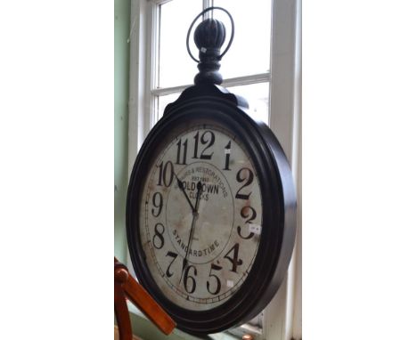 A large decorative wall clock shaped like a pocket watch