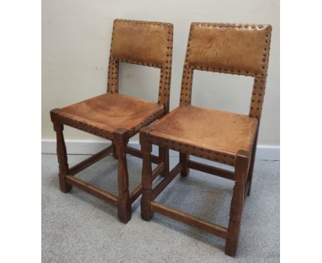 Robert "Mouseman" Thompson set of eight oak brass studded dining chairs, each with hide upholstered back and seat on turned a