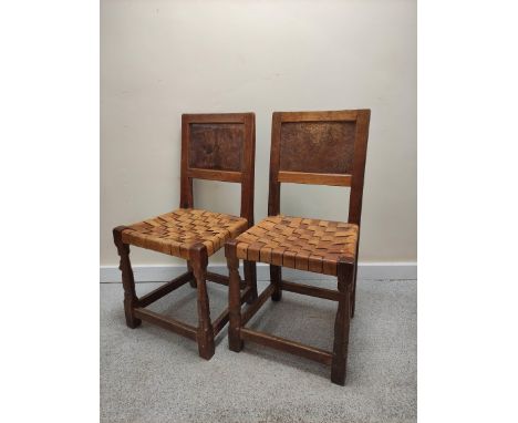 Robert "Mouseman" Thompson set of nine oak dining chairs, each with rustic single panel back above interwoven leather seat on