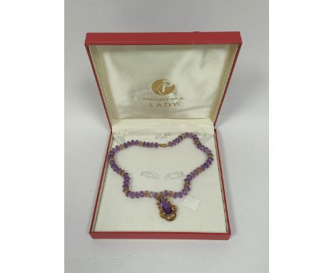 Victorian pendant in gold scrolling mount upon amethyst and citrine faceted bead necklet. 