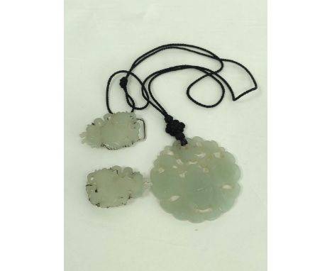 Chinese celadon jade circular pendant and a similar buckle in two parts. (3).&nbsp;