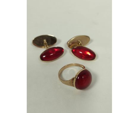Red amber cabochon ring and a pair of similar cuff links, in gold.  Answer to question: We say it is amber coloured but proba