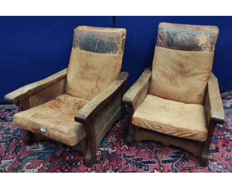 Robert "Mouseman" Thompson, pair of oak easy chairs upholstered in worn hide, with adjustable backs and panelled sides, iron 