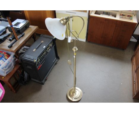 A brass standard lamp with a glass shade