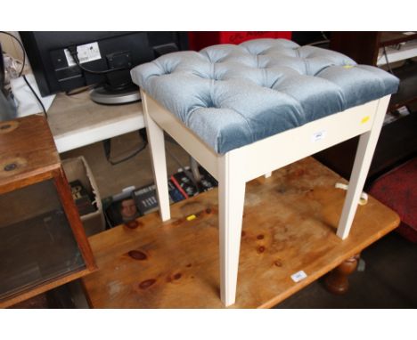 A button down blue upholstered dressing table stool