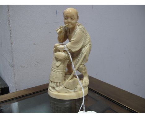 A Late XIX Century Japanese Ivory Figure, carved as a wood cutter and smoking a pipe, oval base, signed, 13cm high.