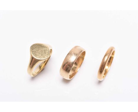 A 22ct gold wedding band, size K, weight approx 4.1g, together with an 18ct gold wedding band, size L and an 18ct gold signet