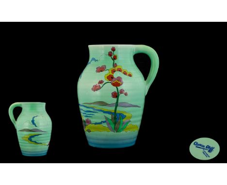 Clarice Cliff For Wilkinson One Handled Jug a turquoise ground jug with painted decoration of foliage amongst landscape, with