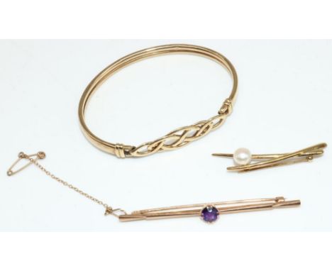 9ct yellow gold bangle with Celtic style clasp, stamped 375, a 9ct yellow gold bar brooch set with purple stone, stamped 9ct,