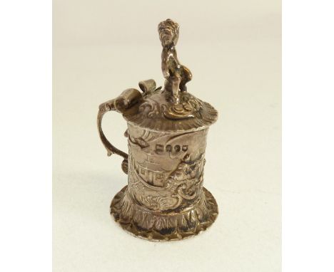 IMPORTED GERMAN SILVER MINIATURE TANKARD, repousse with figures, with skirt base and putti finial to hinged lid, 2" (5cm) hig