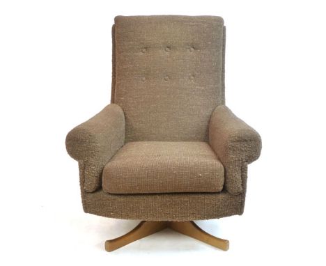 A 1960's button upholstered armchair on a teak four star swivel base