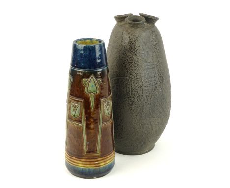 A Romanian black pottery vase with three formed spouts, bearing a paper label stating 'Coop Oltul Miercurea-Ciuc Ceramic neag