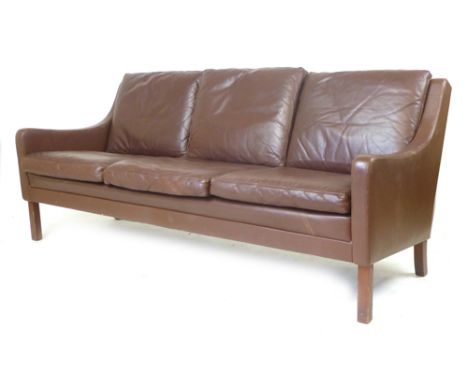 A 1970's brown leather three seater sofa on mahogany square straight feet, in the manner of Borge Mogensen  CONDITION REPORT: