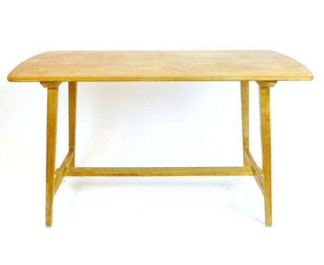 An Ercol elm dining table on beech tapering legs, retailed by Maple & Co., l. 133 cm CONDITION REPORT: Structurally sound but