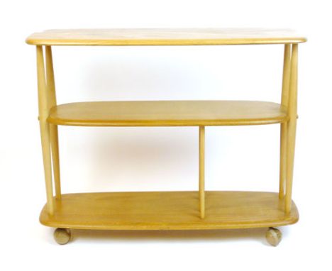 An Ercol elm and beech three tier side table on castors, l. 91 cm CONDITION REPORT: Wear commensurate with age and use, minor
