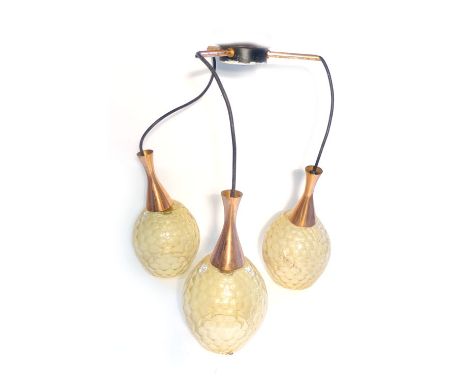 A 1970's copper three branch ceiling light, the three amber moulded glass shades suspended from the central fitting CONDITION