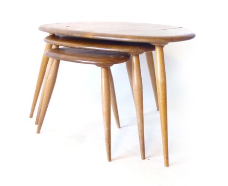 An Ercol nest of three 'Pebble' elm coffee tables on beech supports, max. l. 65 cm CONDITION REPORT: Structurally sound, some