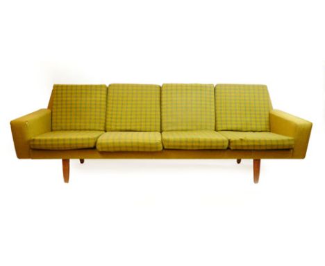 A 1960/70's four seater sofa on teak circular tapering feet CONDITION REPORT: Upholstery tired and ripped in places, structur