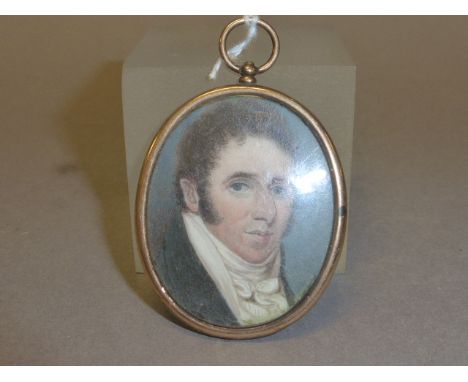 A Georgian Miniature Oval Portrait of a Gentleman painted on mother of pearl with an oval yellow metal framed hair mourning l