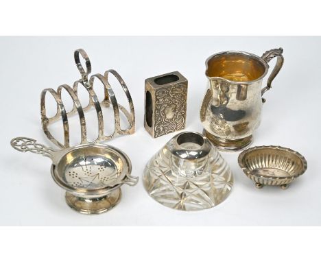 A silver cream jug with scroll handle, Birmingham 1917, a toast rack, tea strainer on non-matching stand, small open salt and