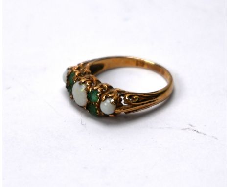 An opal and emerald ring, the three graduated round pale opals with two emeralds to each side, 9ct yellow gold set, size NGoo