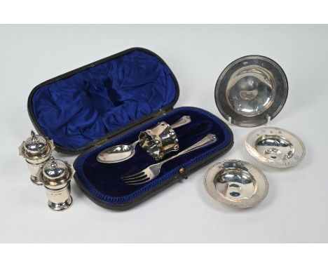 Three small silver Armada dishes, a pair of Edwardian pepper pots and a cased Christening part-set, comprising spoon, fork an