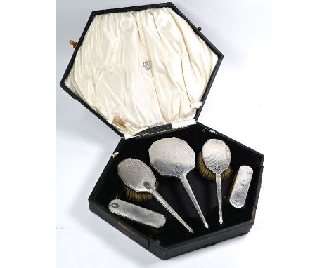 An Art Deco engraved and engine-turned silver six-piece brush set including hand-mirror and comb, Birmingham 1933, in fitted 