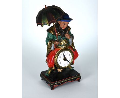 A novelty polychrome painted spelter alarm clock, as a seated parasol holding oriental gentleman, the movement stamped 'EO', 