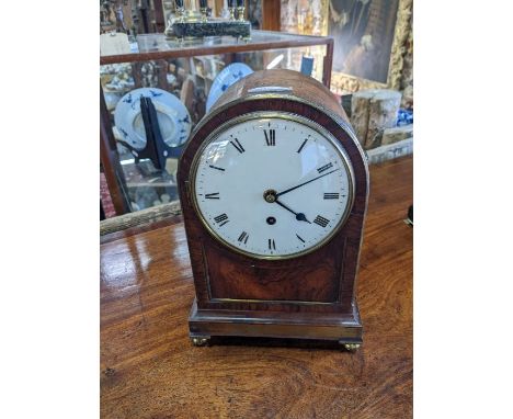 A Regency period rosewood cased single fusee mantel clock, with white enamelled Roman numeral dial, raised on brass ball feet