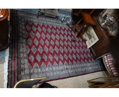 A contemporary Persian Turkoman design carpet, repeating guls on red/brown ground, 270 cm x 188 cm