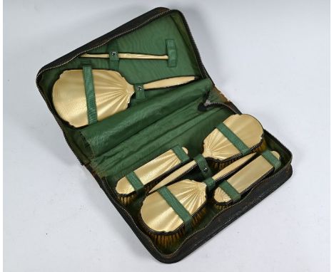 A silver and gold-coloured guilloche enamel five-piece brush set, Birmingham 1936, in silk-lined leather zip-up wallet-caseEn