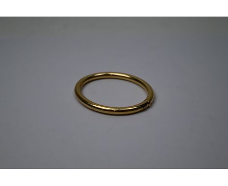 An 18ct yellow gold oval half-hinged bangle of plain form, with concealed clasp, plaque for 'La Papita', 22g approx, 6 cm x 5