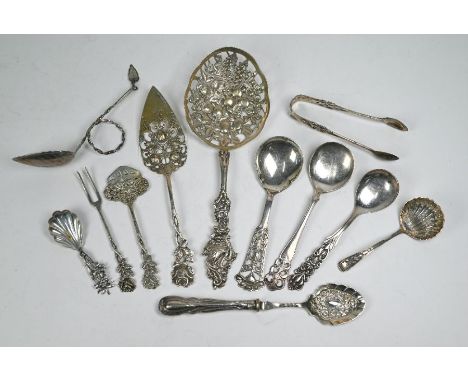 An ornate Swedish silver fruit-serving spoon with richly pierced cat bowl and stem decorated with a swan, to/w a similar past