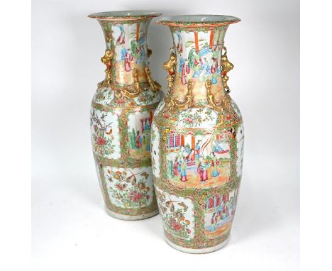 A pair of large Chinese Canton famille rose vases of baluster form with everted foliate rims, each applied with gilt guardian