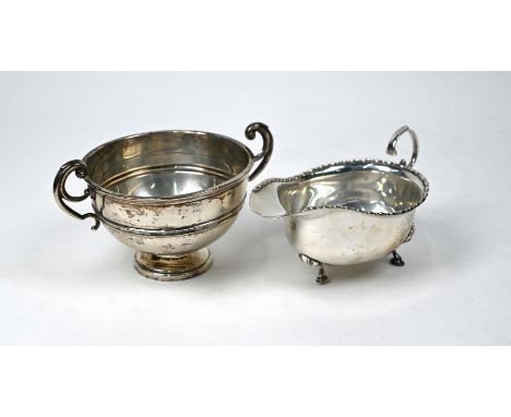 An Edwardian silver two-handled sugar basin (or Christening bowl) on stemmed foot, London 1909, to/w a sauce boat, Birmingham